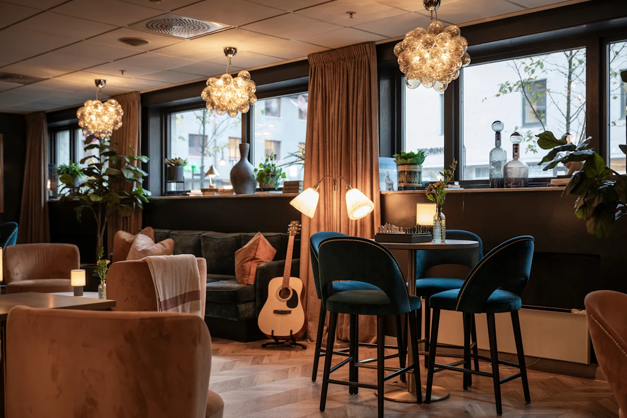 Home Hotel Grand Bodø: A cozy and inviting hotel lounge with comfortable seating, warm lighting, and a relaxed atmosphere.