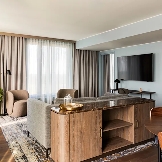 Sviitti Clarion Hotel Helsinki Airportissa. Tilava ja moderni hotellisviitti, jossa on viihtyisä oleskelutila, ruokailutila ja näkymä makuuhuoneeseen.