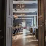 Et innbydende hotellrestaurant- eller barområde med stilige sitteplasser, varm belysning og et synlig BAR-skilt.