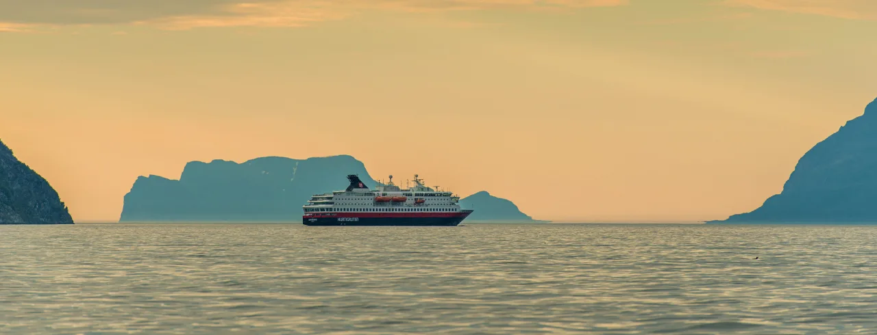 Hurtigruten ship at sea in sunset