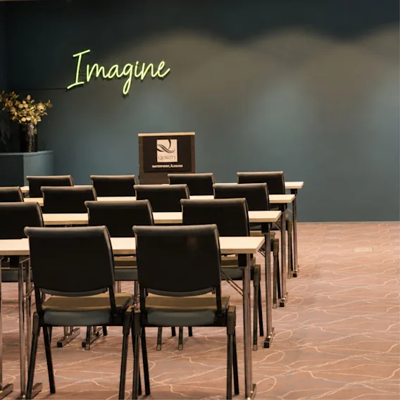 Meeting room Quality Hotel Waterfront with rows of chairs and the word Imagine on the wall.