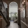 En klassisk hotellobby med en storslået trappe, buede gange og varm belysning, der skaber en indbydende atmosfære.