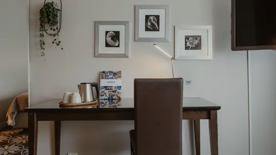 Ett hotellrumsbord med vattenkokare, koppar, en Tromso-broschyr, lampa och inramad konst på väggen. Rumsnummer 330.