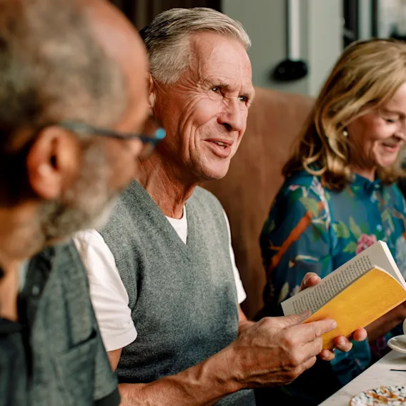 People at a restaurant, one holding a book.