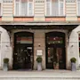 En charmerende bygningsindgang med to mørke døre, en udsmykket markise og potteplanter. Et skilt læser TEMPERANCE HOTEL.