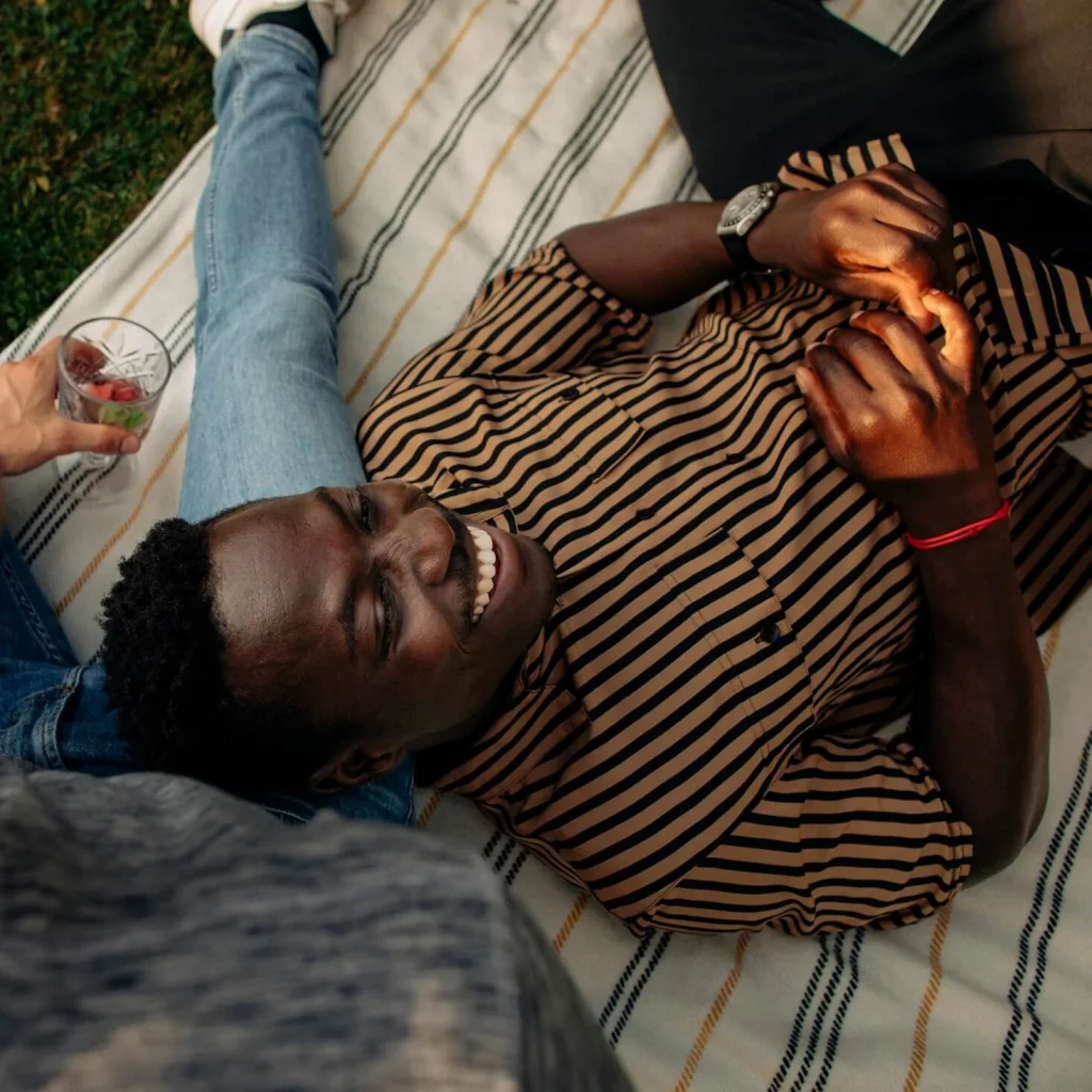 A guy lying in the grass laughing.