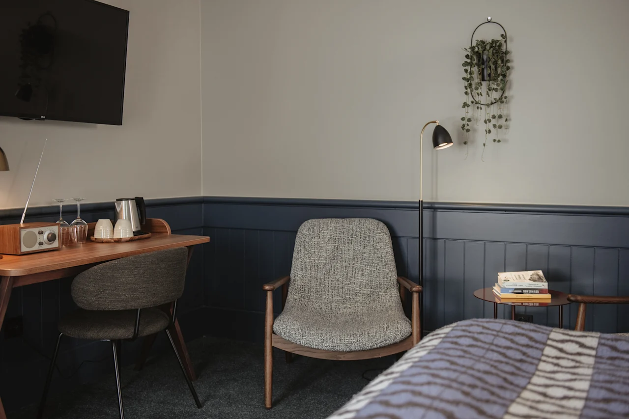 Ett mysigt hotellrum med skrivbord, bekväma sittplatser och en säng, designat för avkoppling och arbete.