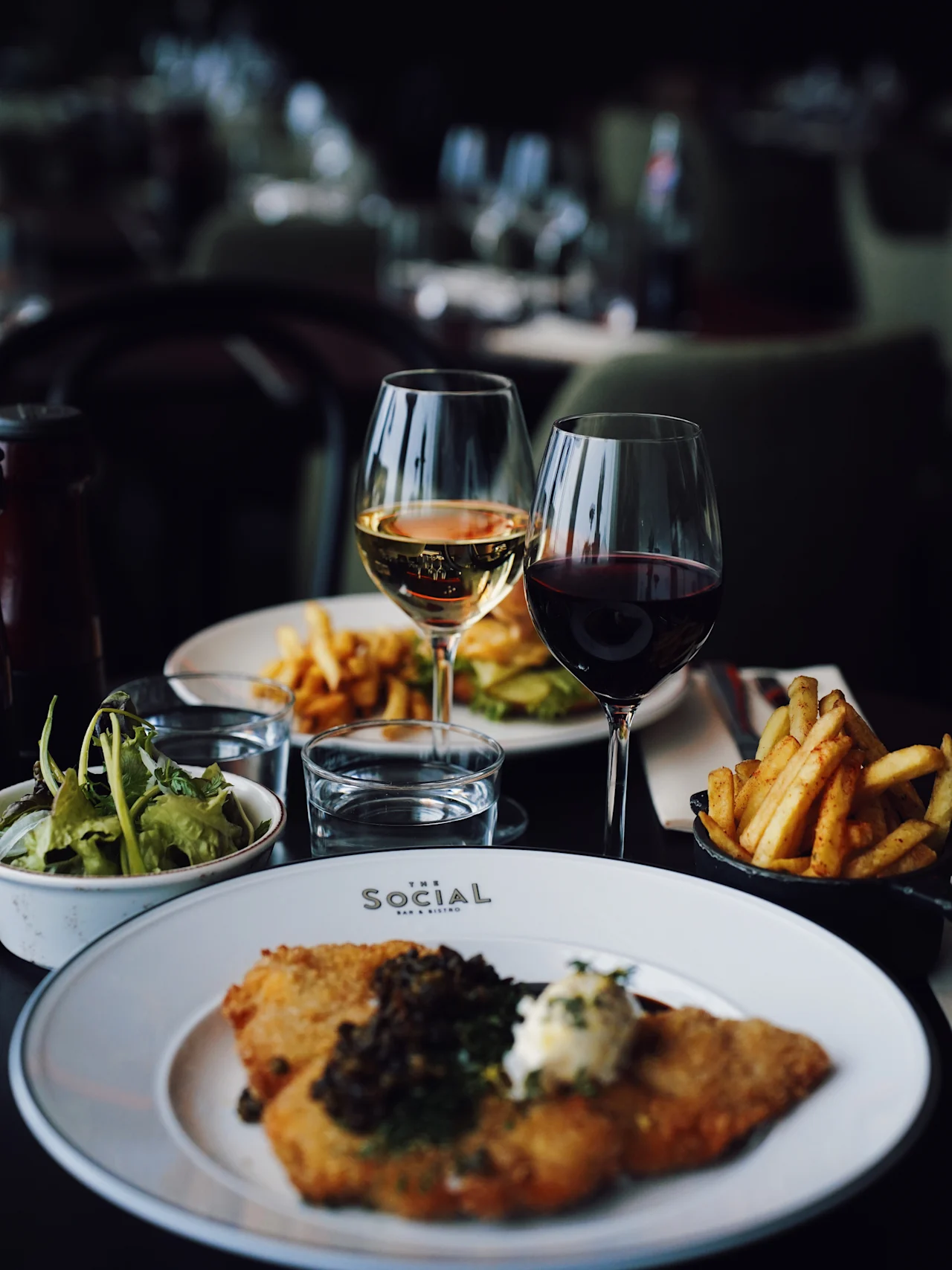 Et deilig måltid på The Social Bar and Bistro, med schnitzel, pommes frites, salat og vin på Quality Hotel Arlanda XPO.