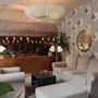 A warm and inviting hotel lounge featuring plush seating, ambient lighting, unique decor, and a cozy fireplace for guests to unwind.