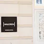 Rakennuksen ulkokuva, jossa kyltti MAJOREN HOME HOTEL koristeellisen valkoisen sisäänkäyntioven vieressä.