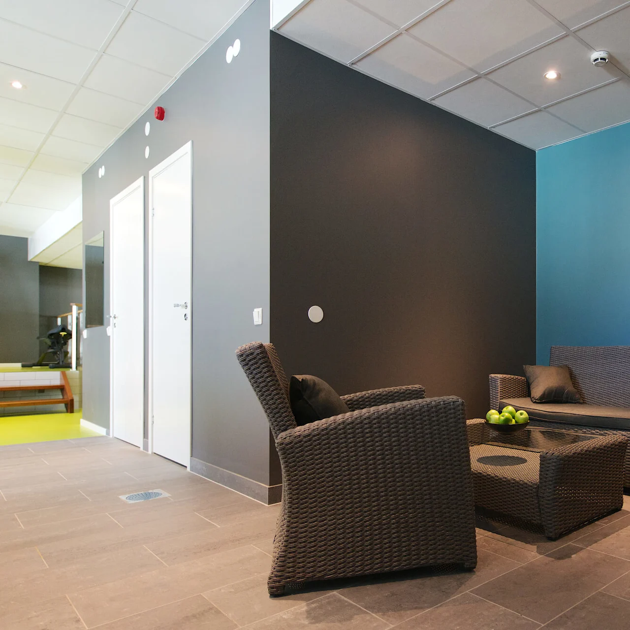 Gray wicker furniture set against a muted color wall scheme in an indoor setting with no activity.