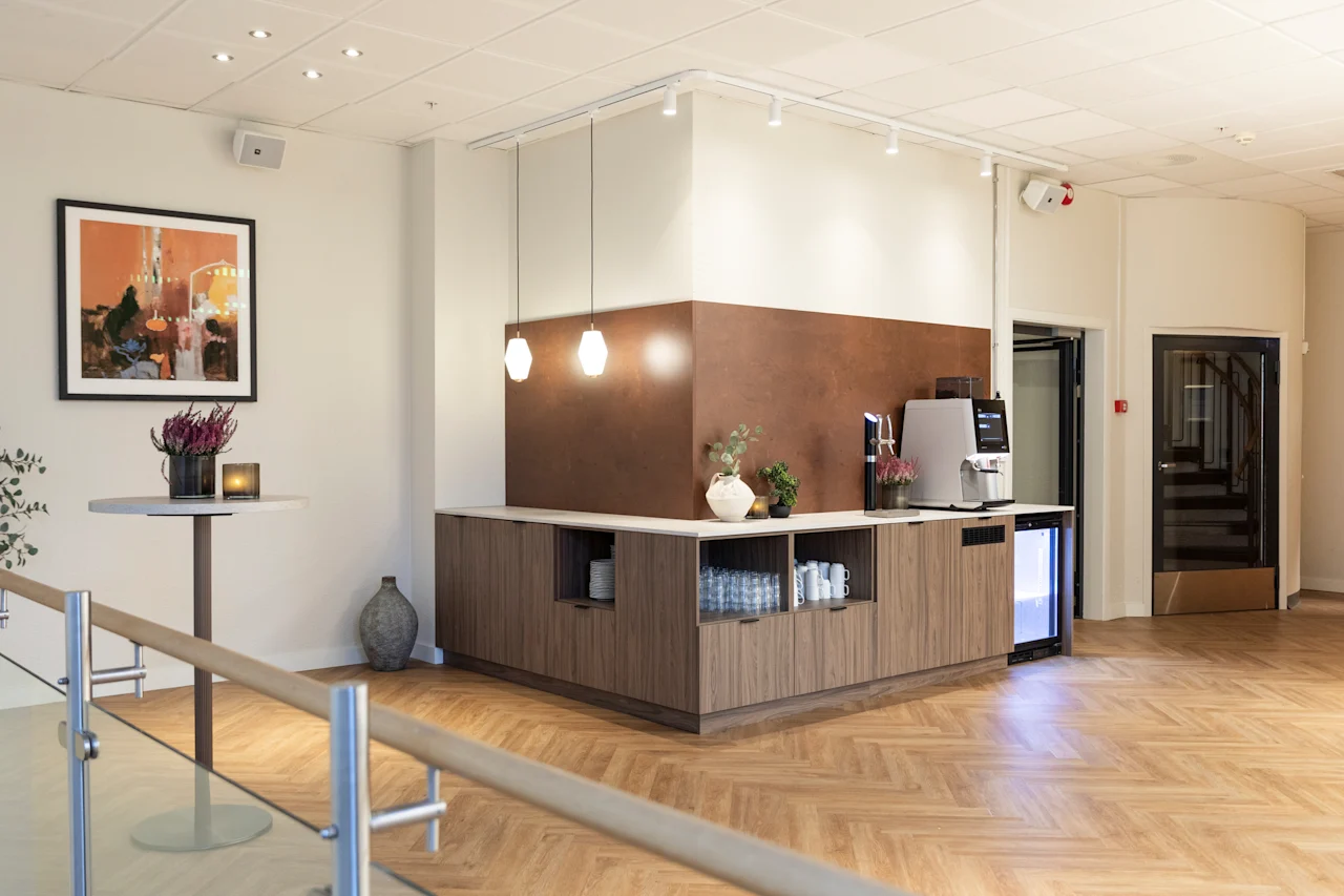 A chic and inviting common area, perfect for a quick break, featuring a self-service station with refreshments and stylish decor.