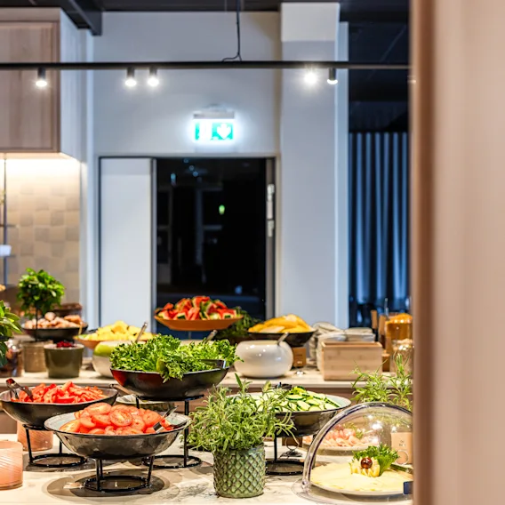 En färgstark buffé med fräscha sallader och grönsaker i en modern restaurangmiljö.