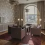 En mysig hotellounge med fåtöljer, ett soffbord och ett stort fönster, perfekt för avkoppling eller informella möten.