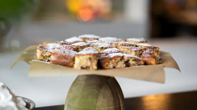 A tempting display of freshly baked cake squares, lightly dusted with powdered sugar, ready to be enjoyed.