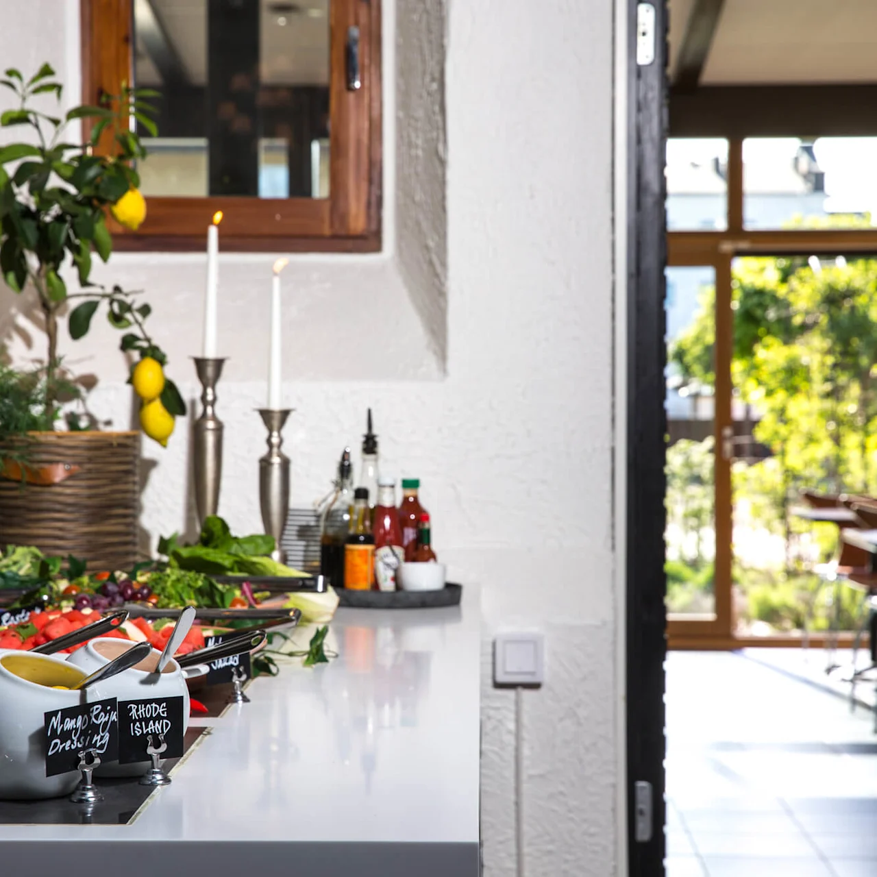 A buffet table with salads and dressings, a blurred dining area in the background. Text on blackboard: "DON'T FORGET TO SHARE YOUR EXPERIENCE ON TRIPADVISOR.COM! ♥ FROM US!"