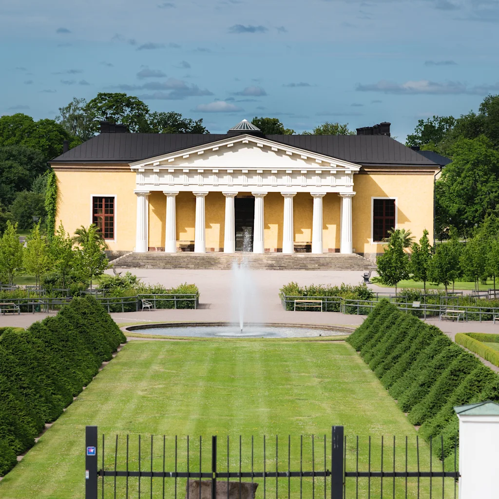 Uppsala botaniska trädgård har en klassisk gul byggnad, en fontän och noggrant underhållna grönområden. BOTANISKA TRADGARDEN