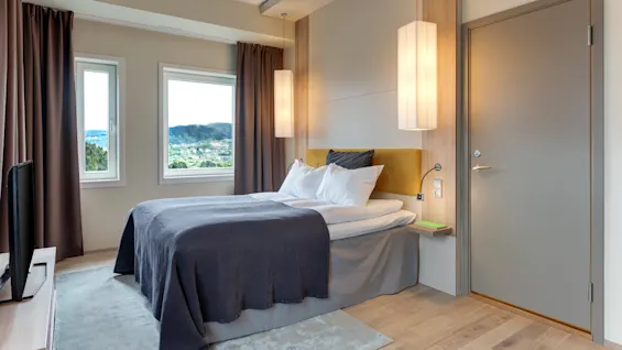 Superior hotellihuone mukavalla sängyllä, luonnonkauniilla ikkunanäkymällä ja modernilla valaistuksella.