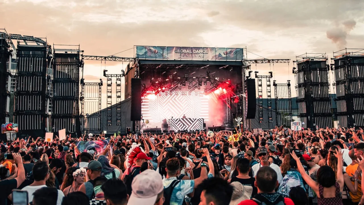 Människor dansar i publiken på festival.