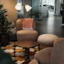 En mysig hotellounge med bekväma sittplatser, ett soffbord och en stor växt, som inbjuder gästerna att koppla av.