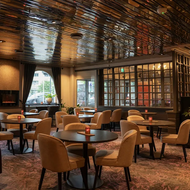 En hotellounge med reflekterende loft, komfortable siddepladser, pejs og klaver, varm og indbydende.