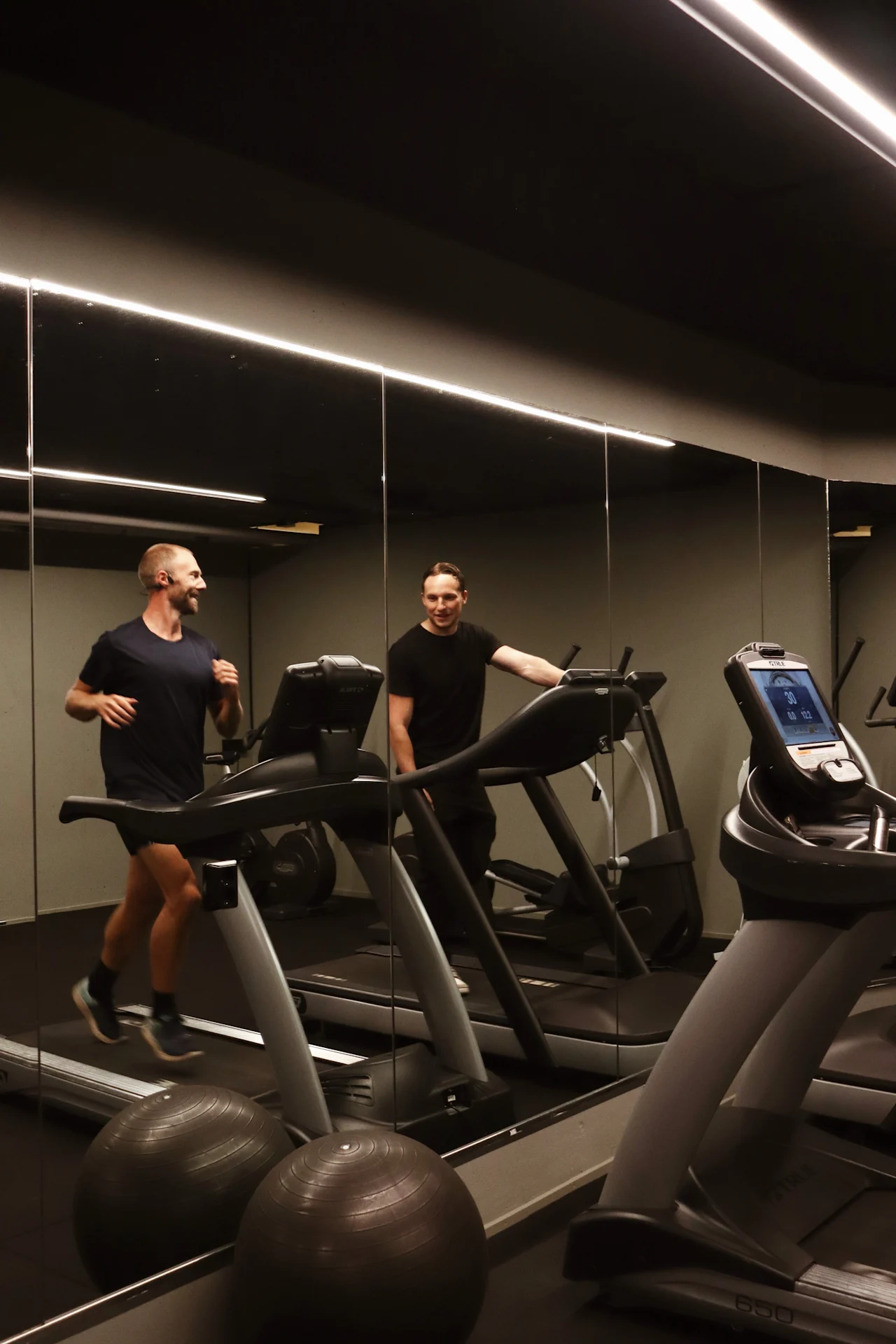 Gjester trener i det moderne treningsrommet på Quality Hotel Park Södertälje, med en person som løper på en tredemølle.