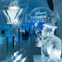 Isskulptur af en mand med høj hat, der løfter armen. Omgivelserne er et iset interiør med skilte med teksten "ICEBAR BY ICEHOTEL" og "Welcome to TORNEÄLV".
