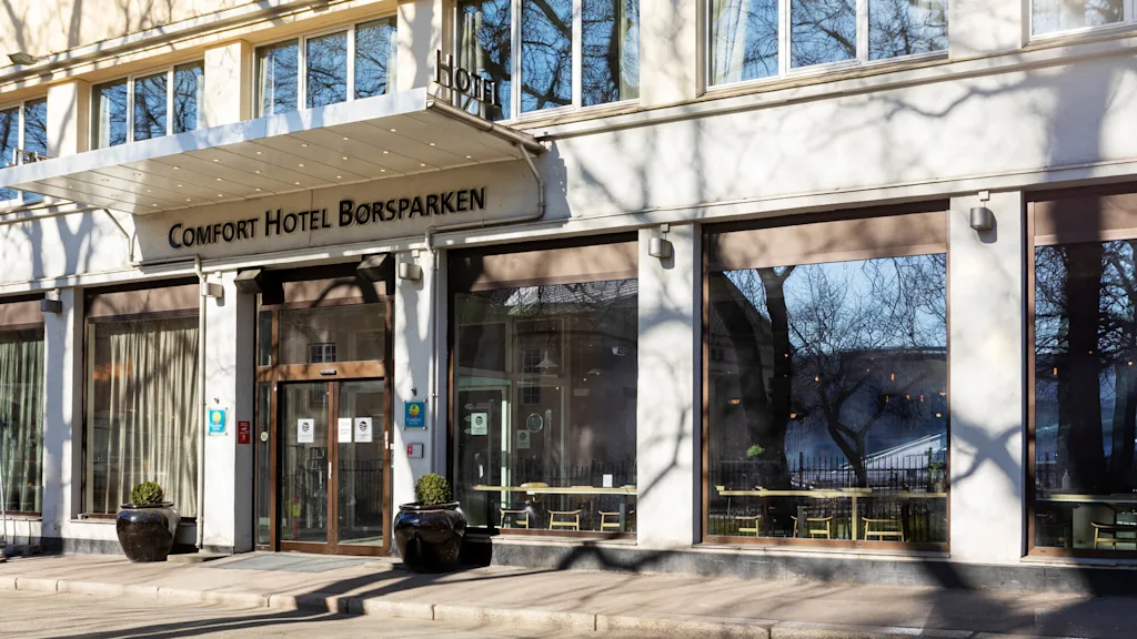 Hotellin sisäänkäynti, "Comfort Hotel Börsparken", selkeä päivä, puun varjo julkisivulla.