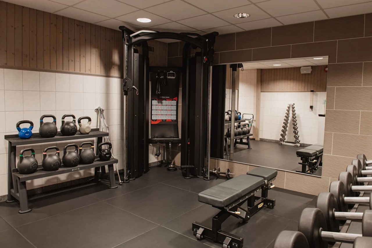 Et moderne og velutstyrt treningsstudio, som tilbyr et utvalg av utstyr for en omfattende treningsøkt, fra frivekter til kabelmaskiner.