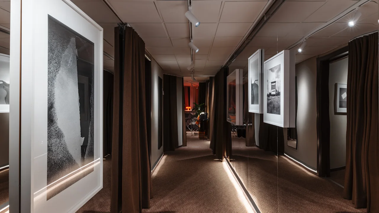 Stratum Suite by Bernadotte ja Kylberg Clarion Hotel Sign. Tyylikäs käytävä, jossa kehystettyä taidetta, ruskeat verhot ja lämmin valaistus.