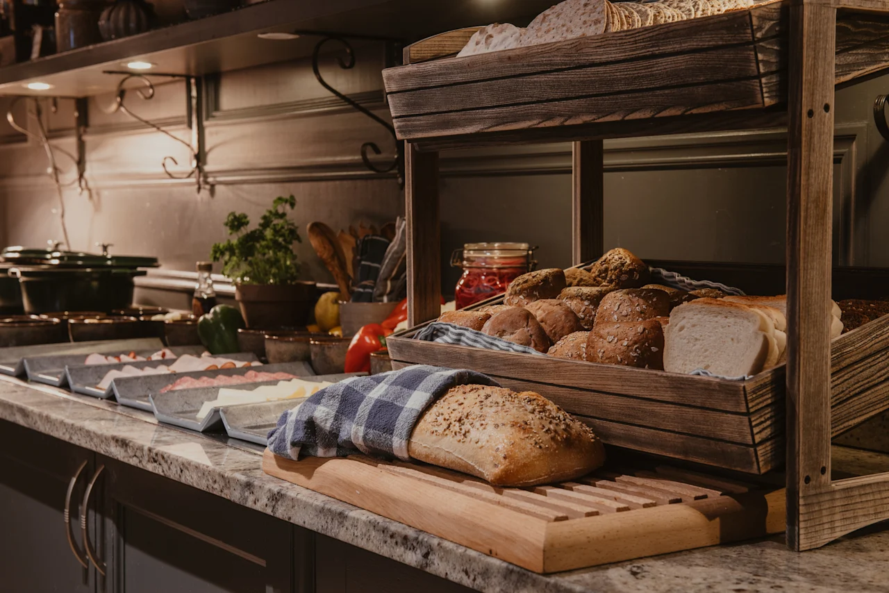 Home Hotel Kung Oscar breakfast buffet featuring a selection of fresh bread, rolls, and other delicious morning foods.