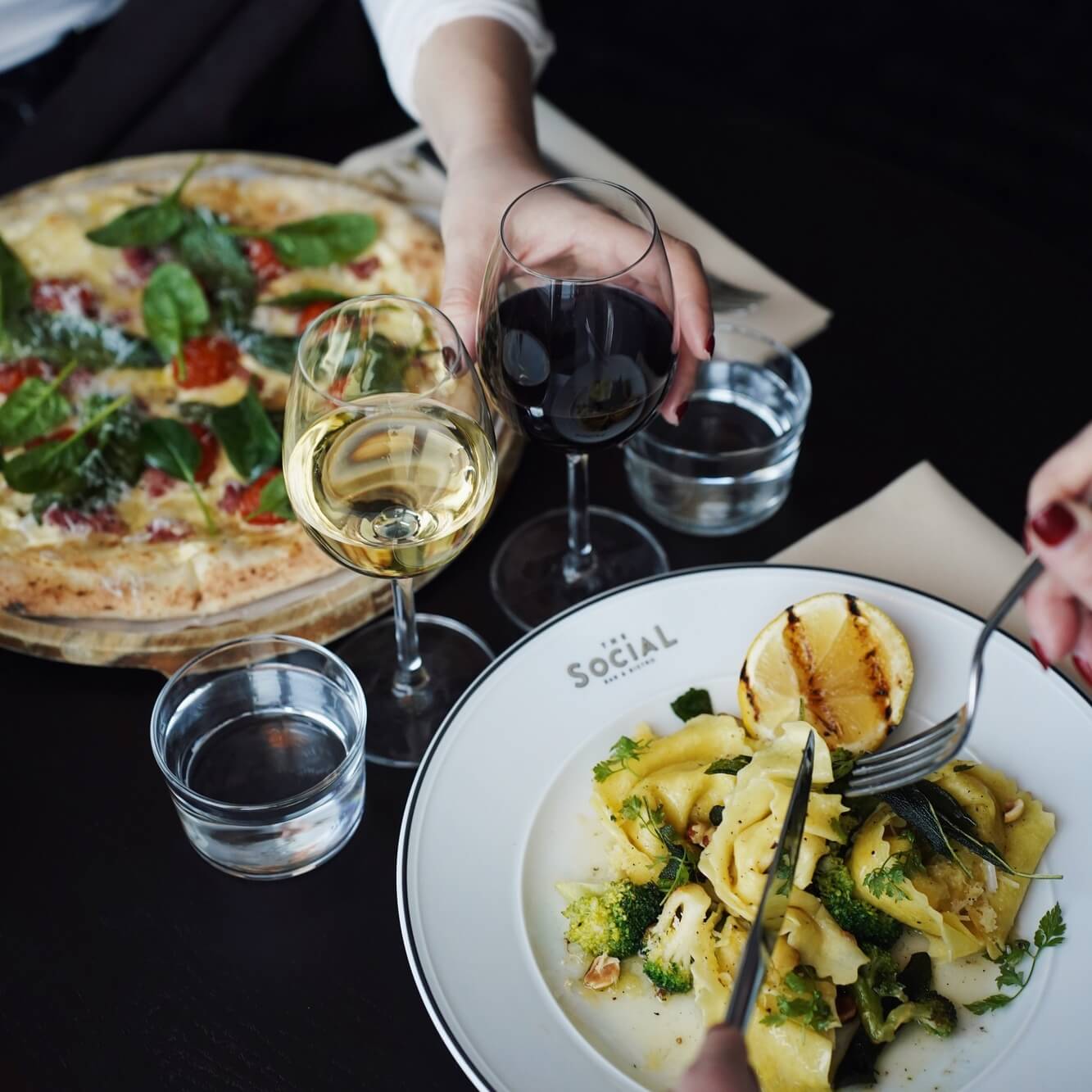 Two people eating pasta and meat at The Social Bar & Bistro.