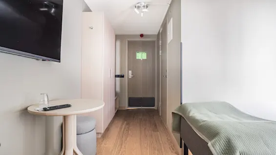 A welcoming and functional hotel room, ready for a guest's stay, with a comfortable bed and entertainment options.