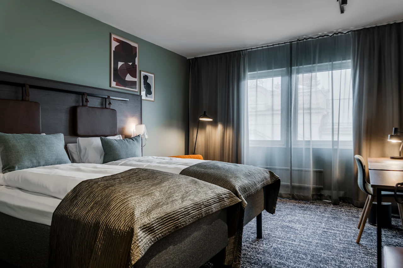 Ett bekvämt hotellrum på Quality Hotel Luleå med två sängar, ett skrivbord och ett fönster.