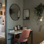 Et koselig hotellrom med en komfortabel seng og et velutstyrt skrivebordsområde, med vannkoker, bøker og en radio. Getbonello