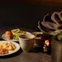 En varm og indbydende morgenmadsbuffet på et træbord, med et udvalg af retter, kaffe og appelsinjuice.