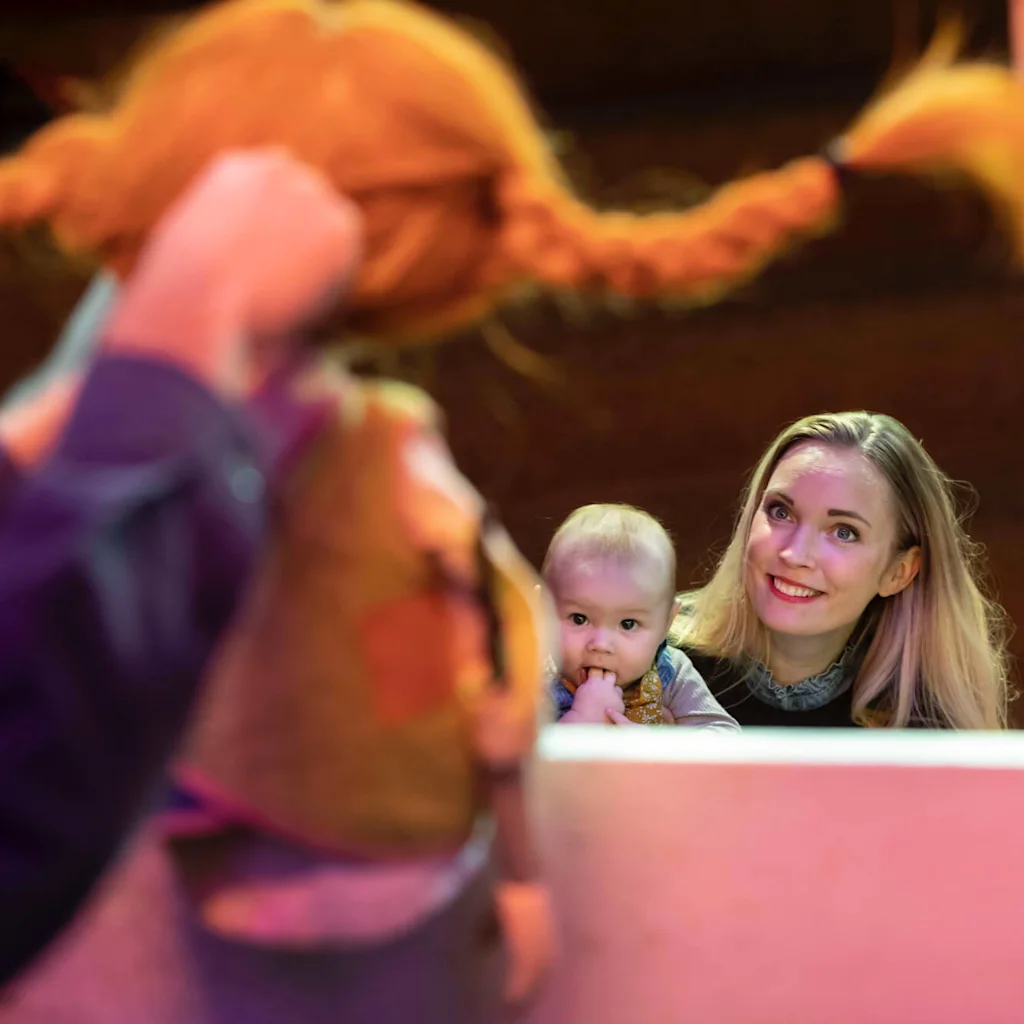 Familj tittar på en av karaktärerna i Astrid Lindgrens böcker på barnmuseet Junibacken i Stockholm.