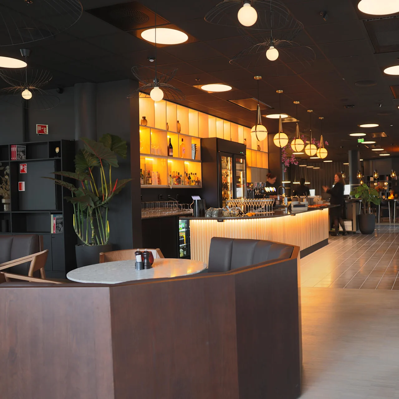An inviting restaurant interior with ambient lighting, a bar, and seated diners.