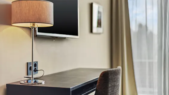En mysig arbetsplats på Quality Hotel Ulstein med skrivbord, lampa och stol, perfekt för produktivitet eller avkoppling.