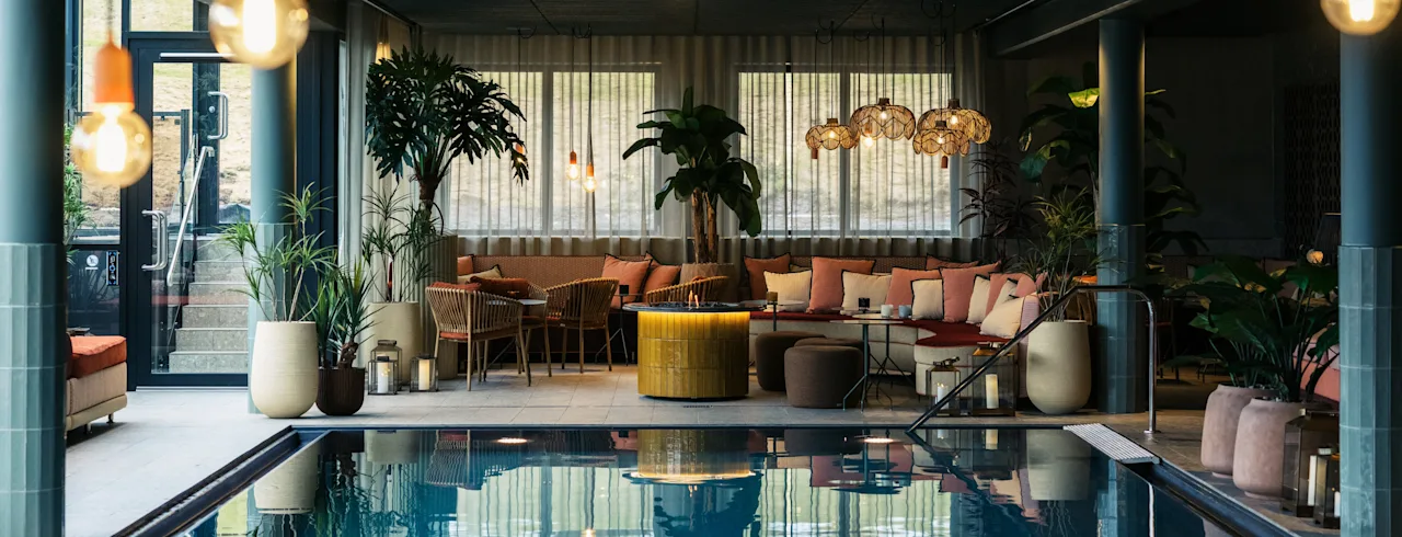 Indoor pool area at Lily Country Club with comfortable seating, lush plants, and warm, inviting lighting.