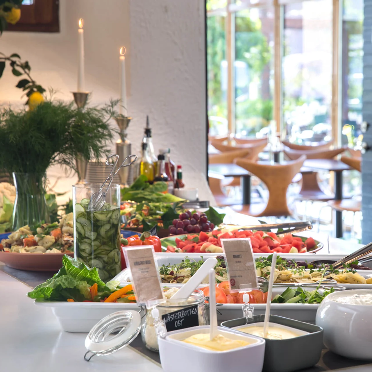 A salad buffet with various fresh vegetables, dressings, and garnishes in a brightly-lit restaurant setting.