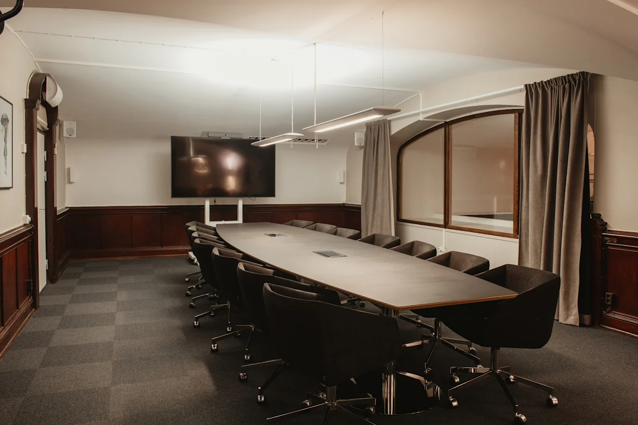 Ett modernt konferensrum med ett stort bord och stolar, perfekt för möten på Home Hotel Grand, Helsingborg.