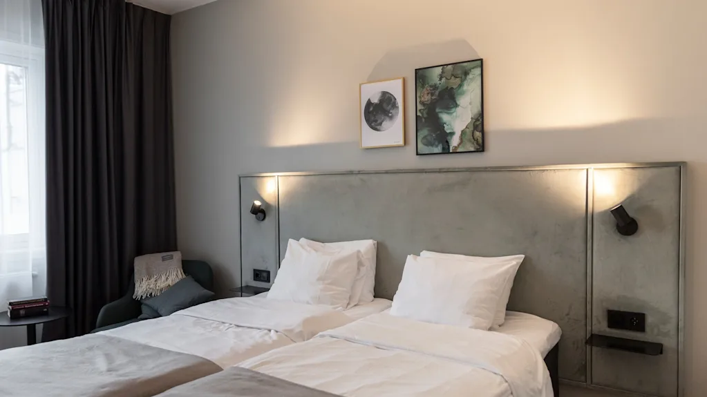 Astu mukavuuteen! Tässä kutsuvassa hotellihuoneessa on kaksi viihtyisää sänkyä, tyylikäs sängynpääty pehmeällä valaistuksella ja modernia taidetta.