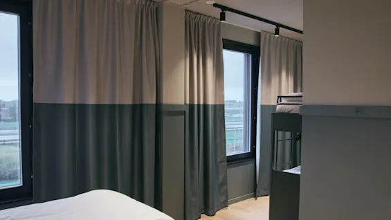 Rum på Stopover Hotel Falkenberg med säng och våningssängar, designat för en bekväm vila under resan.