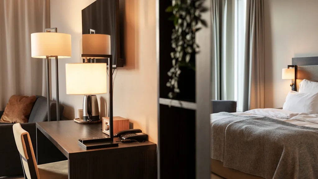 Et hyggeligt hotelværelse med skrivebord og en behagelig seng, perfekt til arbejde og afslapning.