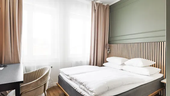 Valoisa ja kutsuva hotellihuone Comfort Hotel Linköping Cityssä, jossa on mukava sänky ja työpiste.