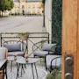 An inviting outdoor patio with comfortable seating and small tables, perfect for relaxation, next to a street with a 30 sign.