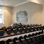 Dumbbells hviler på en rack i et godt belyst treningsrom med en speilvegg som reflekterer utstyr. Tekst på speilet: "YES I DEEP REDRM THE EKOOR" (baklengs).