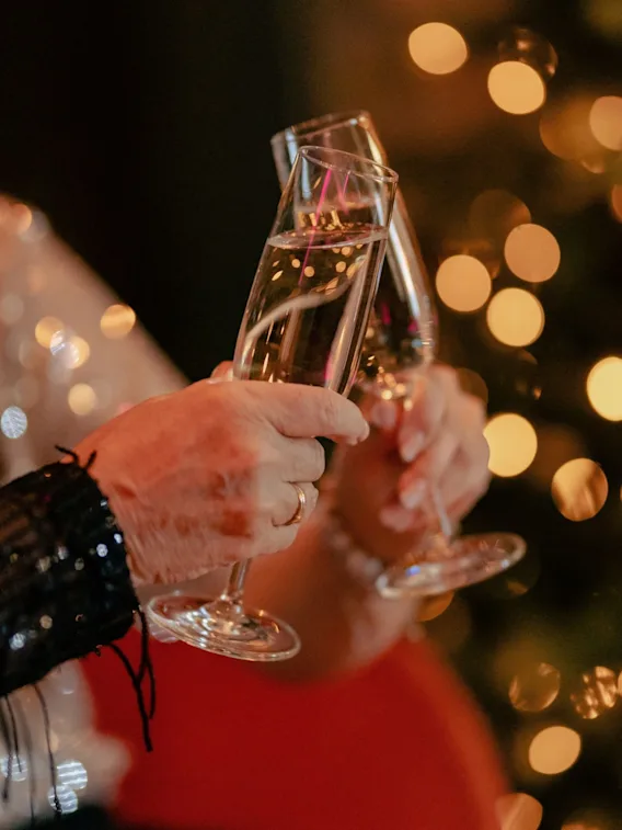 To personer som skåler med champagneglass i festlig belysning.