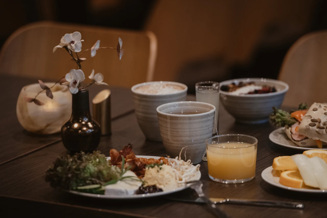 Et bord dækket med en lækker morgenmad, inklusive kaffe, te, juice og forskellige retter, på Home Hotel Norre Park i Halmstad.